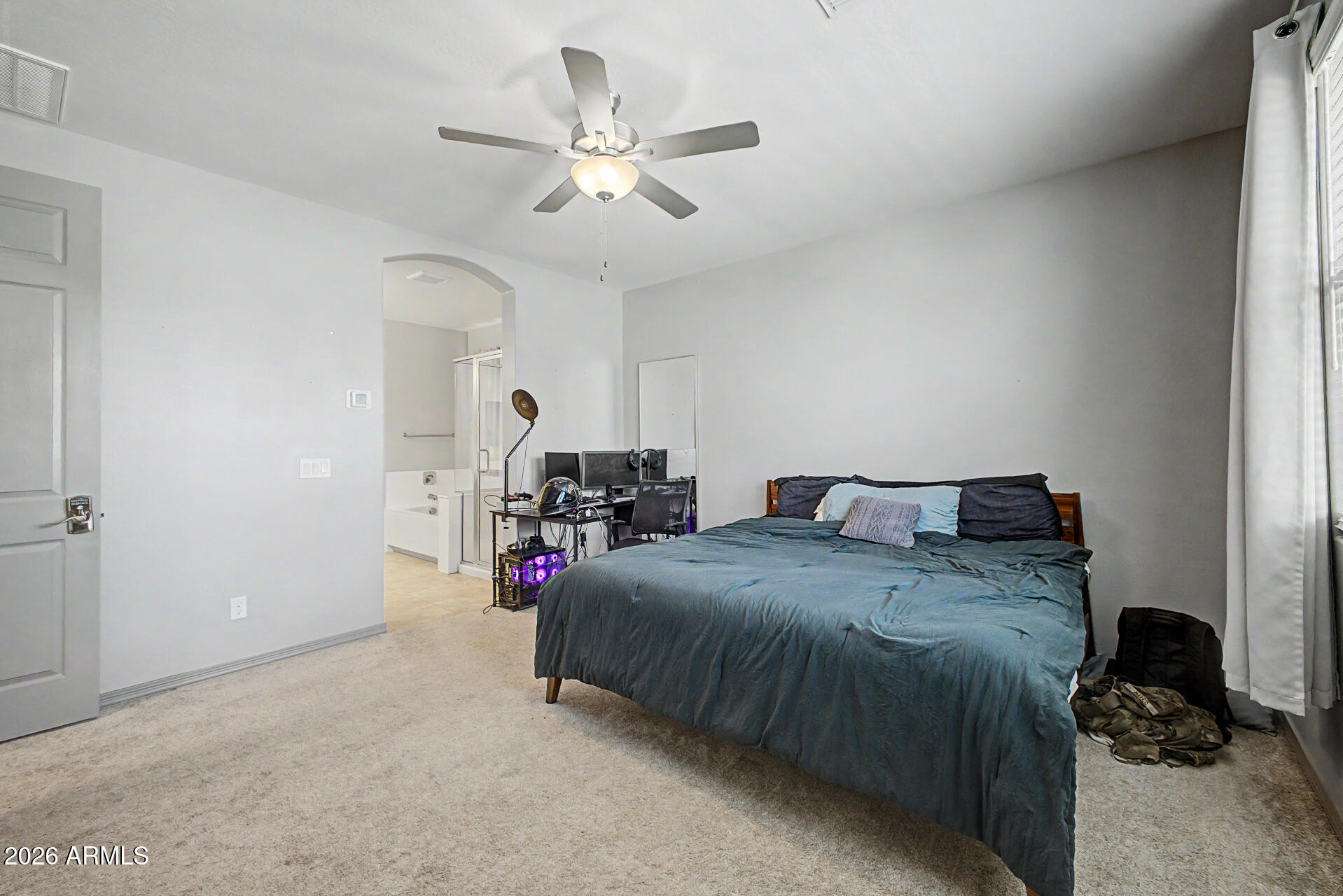 15088 West Garfield Street Goodyear, AZ 85338 - Photo 14 of 31 a bed room with a bed and a ceiling fan