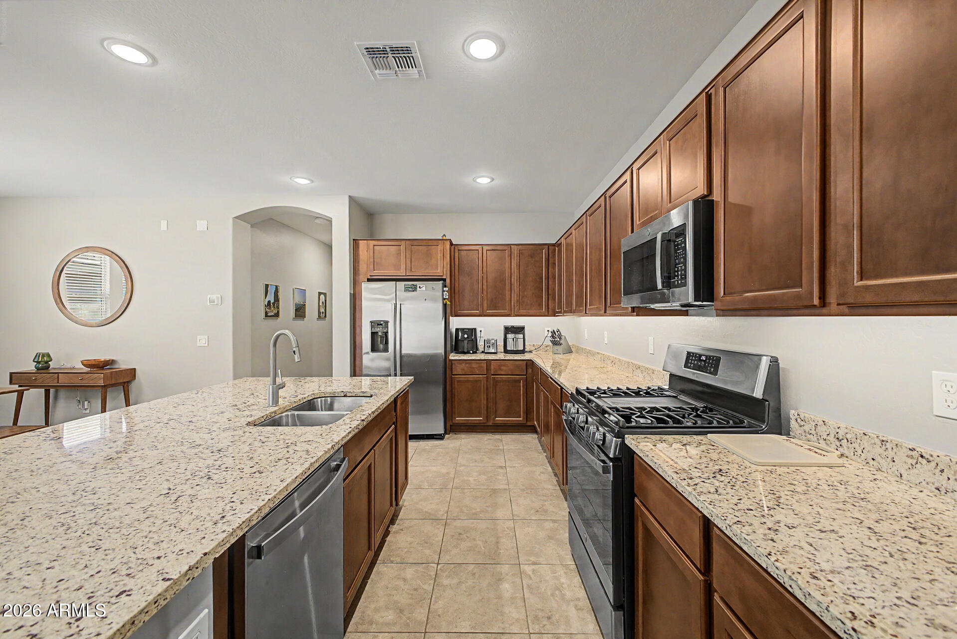 15088 West Garfield Street Goodyear, AZ 85338 - Photo 10 of 31 a kitchen with stainless steel appliances granite countertop a kitchen island a stove and a sink