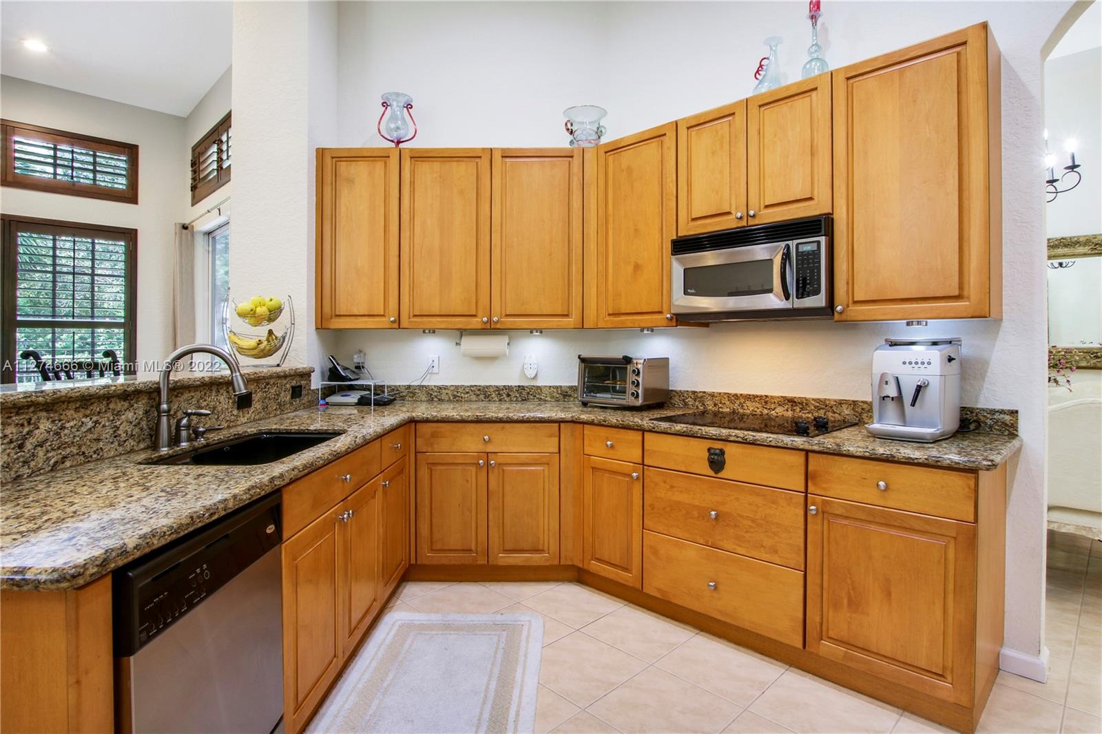 116 Via Rosina Jupiter, FL 33458 - Photo 9 of 32 a kitchen with stainless steel appliances granite countertop a sink stove and microwave