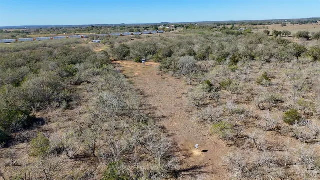 a view of a dry yard with trees