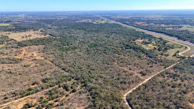an aerial view of house with yard and mountain in the background