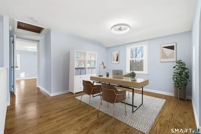 a view of a workspace room with wooden floor and windows