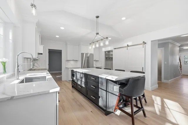a kitchen with stainless steel appliances a sink stove and wooden cabinets
