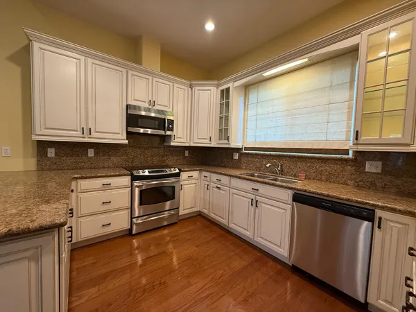 a kitchen with stainless steel appliances granite countertop a stove a sink and a microwave
