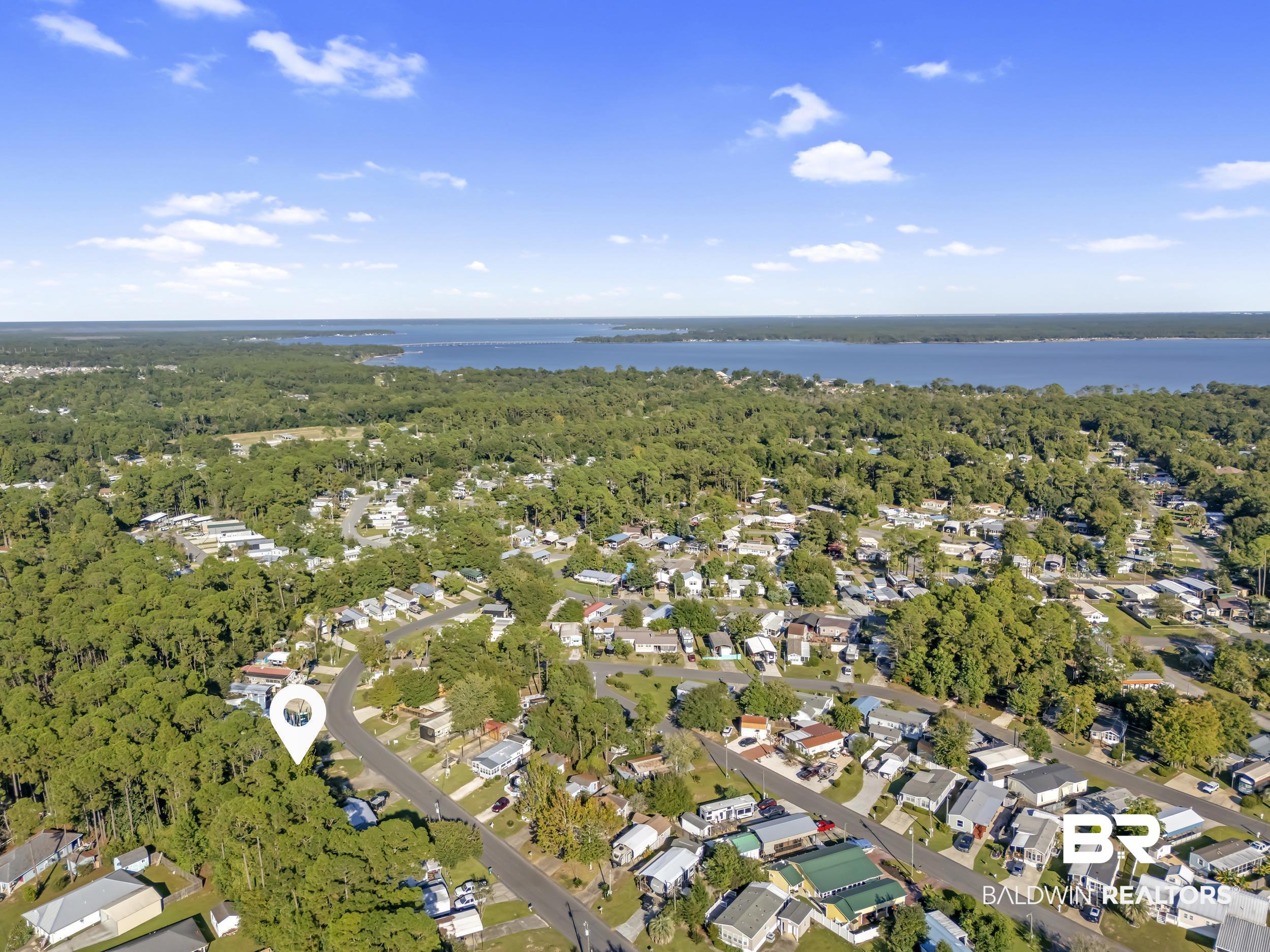 182 Defuniak Loop Lillian, AL 36549 - Photo 15 of 21 Aerial perspective of suburban area with a large body of water and a heavily wooded area
