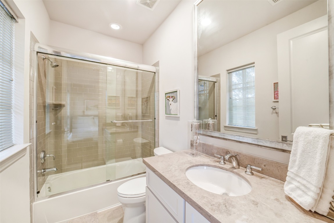 15943 Morgan Street Sugar Land, TX 77478 - Photo 28 of 41 a bathroom with a granite countertop sink toilet mirror and shower