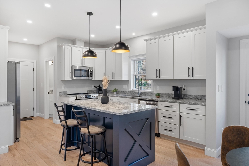 245 Brookside Road Athol, MA 01331 - Photo 3 of 27 a kitchen with stainless steel appliances granite countertop a sink a stove a refrigerator and island with wooden floor