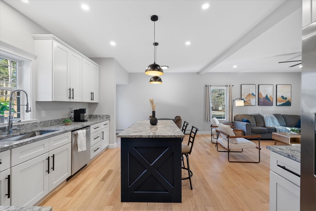 245 Brookside Road Athol, MA 01331 - Photo 6 of 27 a open kitchen with stainless steel appliances granite countertop a stove top oven a sink dishwasher and white cabinets with wooden floor