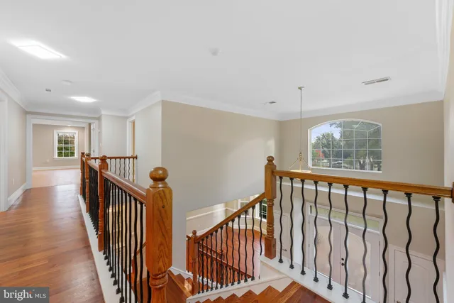 a view of a hallway with wooden floor and staircase