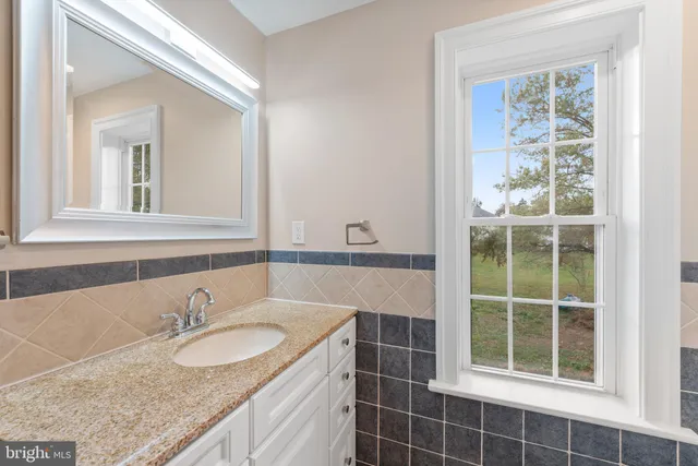 a bathroom with a granite countertop sink a shower and a mirror