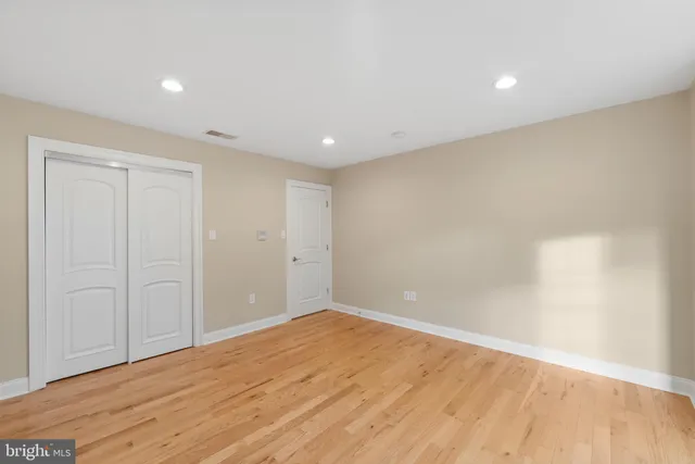 a view of empty room with wooden floor and windows