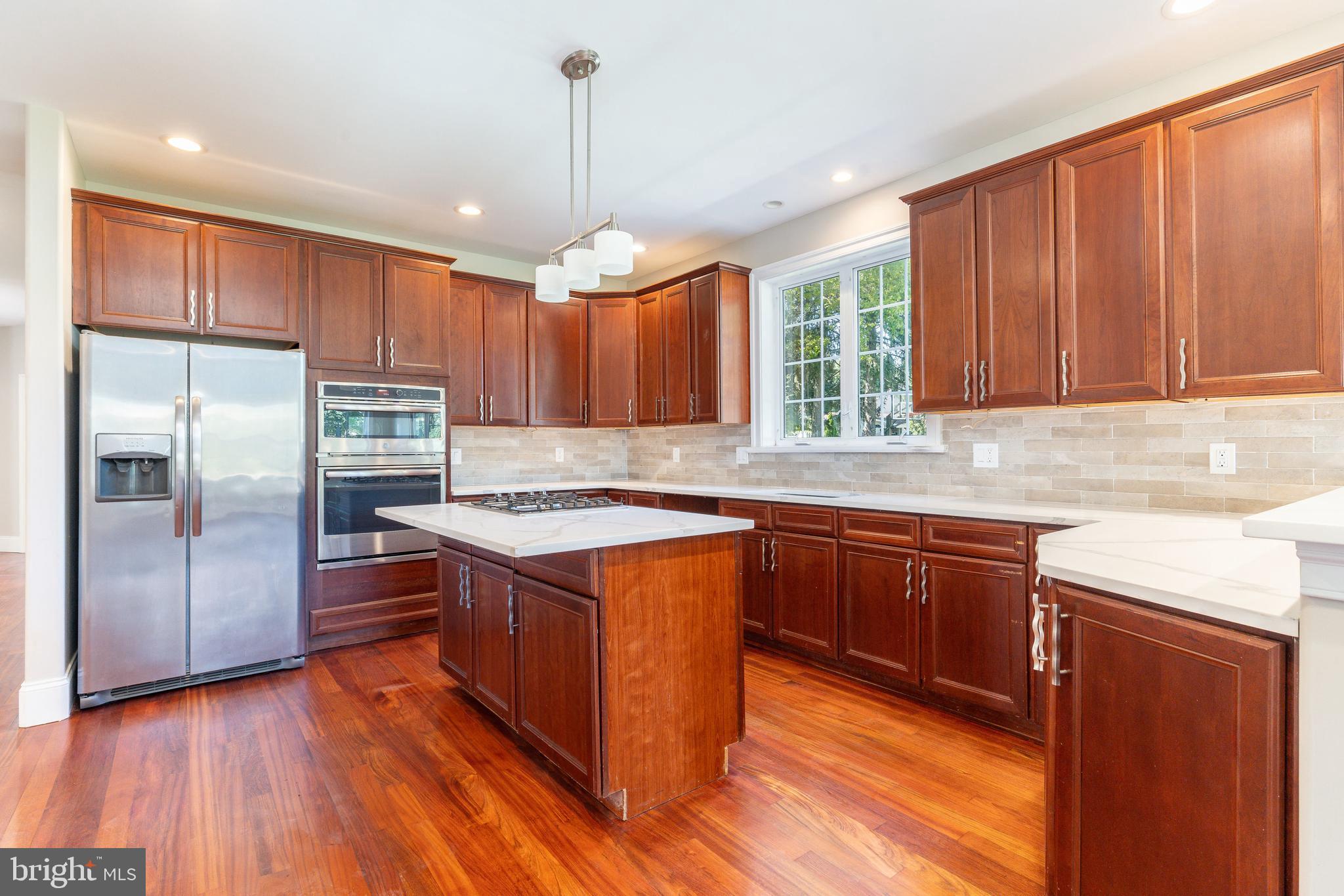 1060 Welsh Road Philadelphia, PA 19115 - Photo 4 of 62 a kitchen with stainless steel appliances granite countertop wooden cabinets a window a sink and a counter space