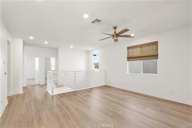 a view of a big room with wooden floor and windows