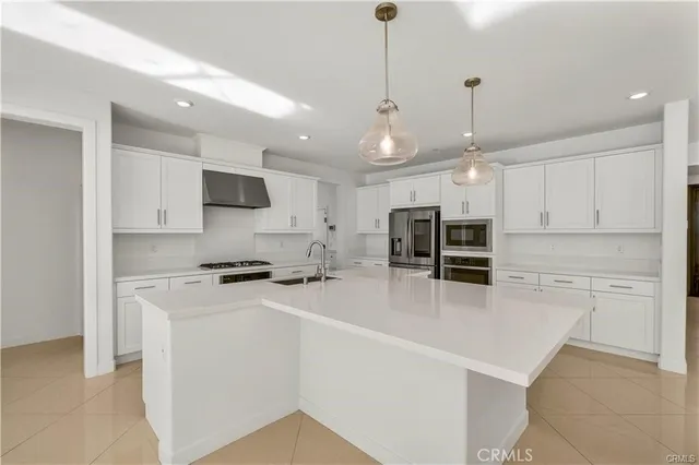 a large white kitchen with kitchen island granite countertop a sink cabinets and a stove