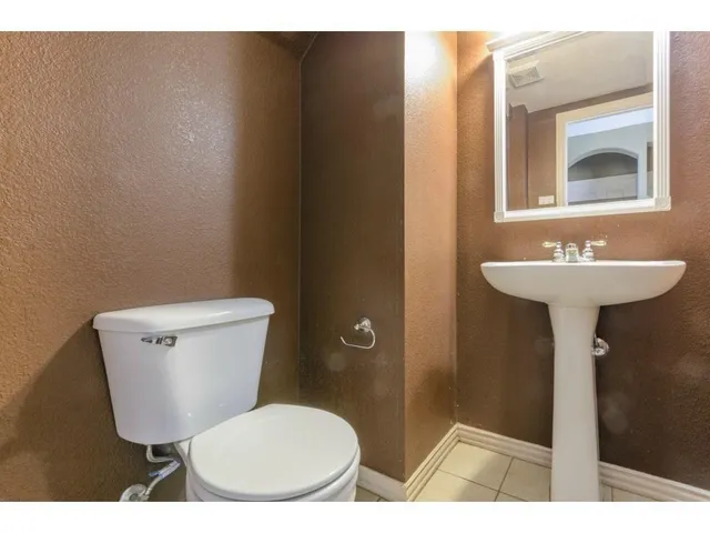 a bathroom with a toilet a sink and mirror