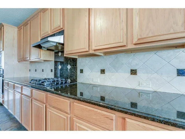 a kitchen with stainless steel appliances granite countertop a sink and cabinets
