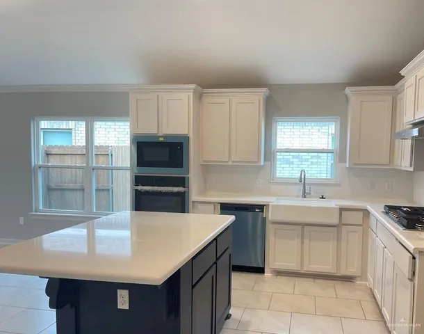 a kitchen with a sink a stove a microwave and cabinets