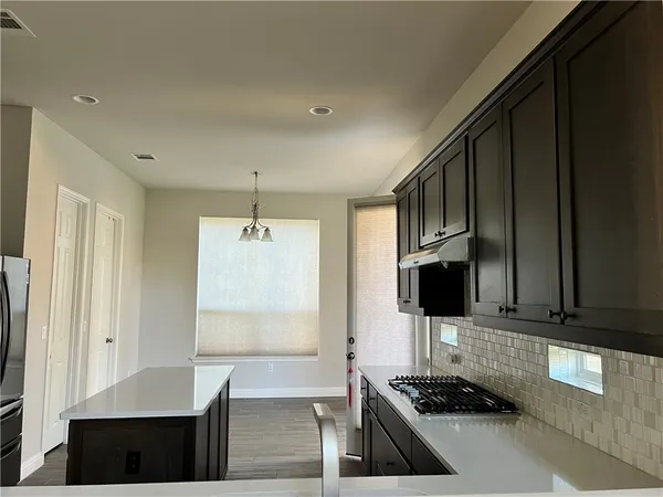 a kitchen with granite countertop a stove and a refrigerator