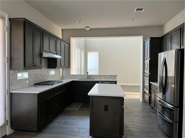 a kitchen with stainless steel appliances granite countertop a refrigerator stove and sink