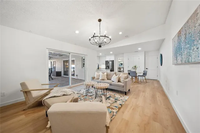 a living room with furniture a chandelier and a dining table