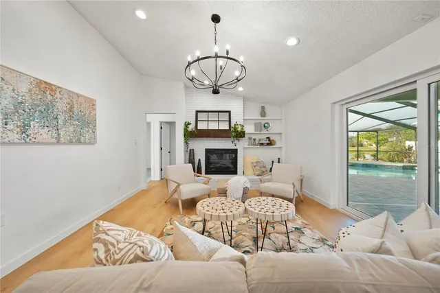 a living room with furniture a fireplace and a chandelier