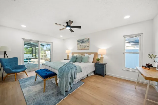 a spacious bedroom with a bed a table and chair