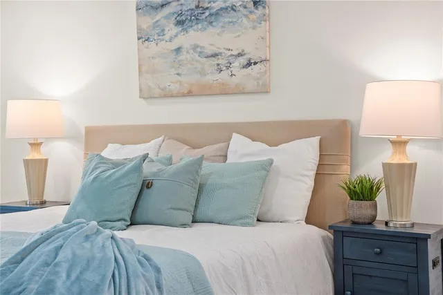 a large bed sitting in a bedroom and a lamp