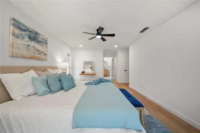 a bed room with bed and a painting on the wall