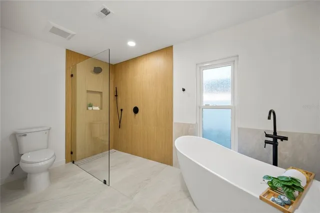 a bathroom with a granite countertop sink a toilet and shower