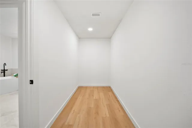 a view of a hallway with wooden floor