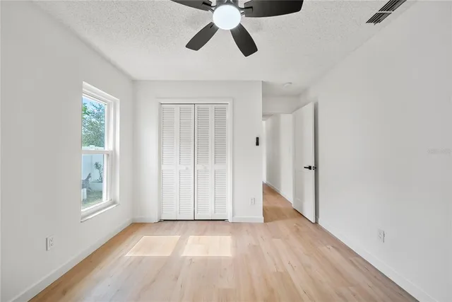 a view of empty room with wooden floor and window