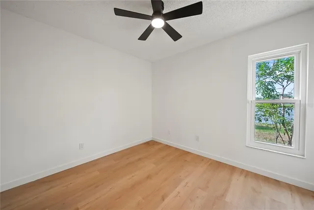 an empty room with a window and a fan