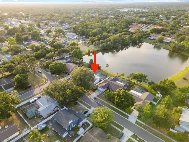an aerial view of a house with a yard and lake view