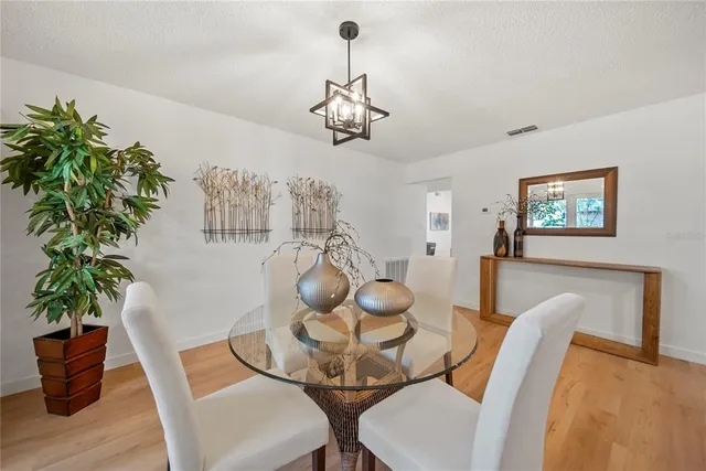 a view of a dining room with furniture wooden floor and chandelier