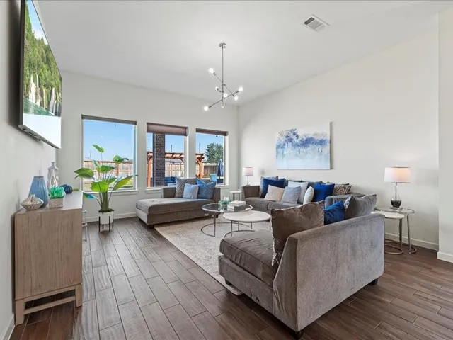 a living room with furniture and a wooden floor