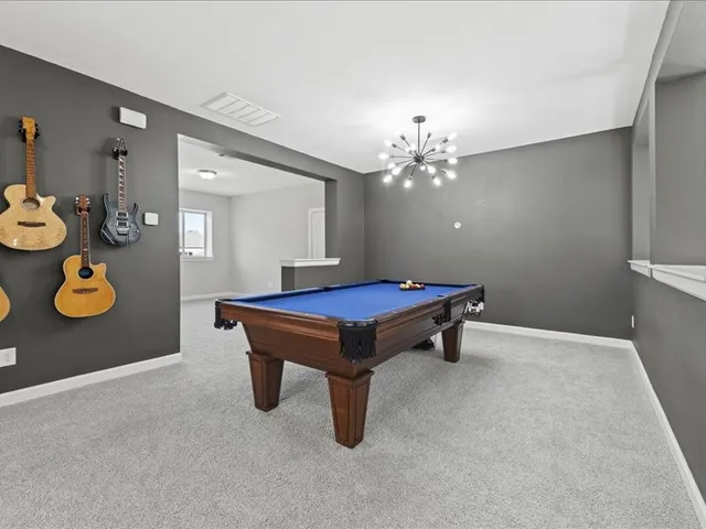 a room with pool table and windows