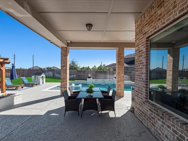 a view of a patio with a table chairs and a floor to ceiling window