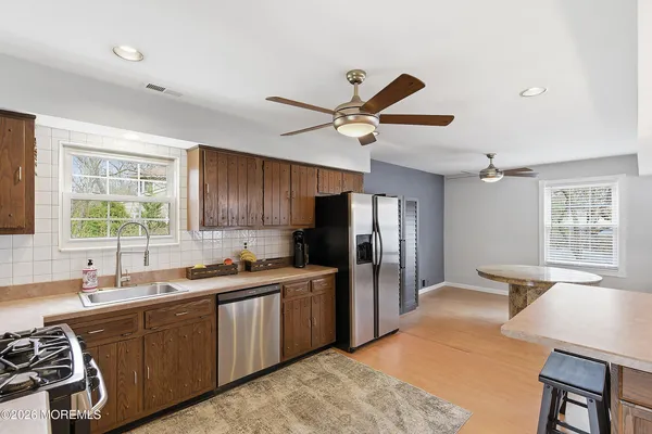 a kitchen with stainless steel appliances granite countertop a sink refrigerator stove and refrigerator