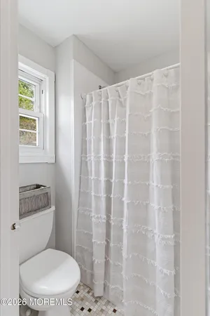 a white toilet sitting next to a shower curtain