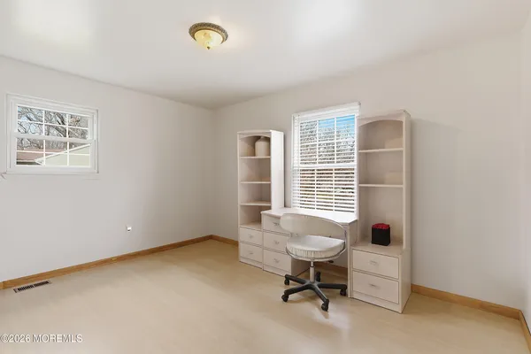 a view of a livingroom with workspace and a window