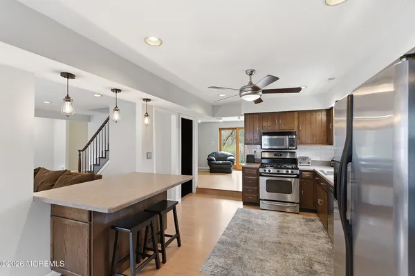 a kitchen with a refrigerator a sink dishwasher a stove and a refrigerator with wooden floor