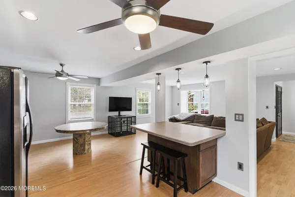 a kitchen with a stove a refrigerator and a flat screen tv