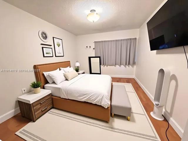 1950 West 54th Street, Unit 413 Hialeah, FL 33012 - Photo 7 of 15 a spacious bedroom with a bed and a flat screen tv