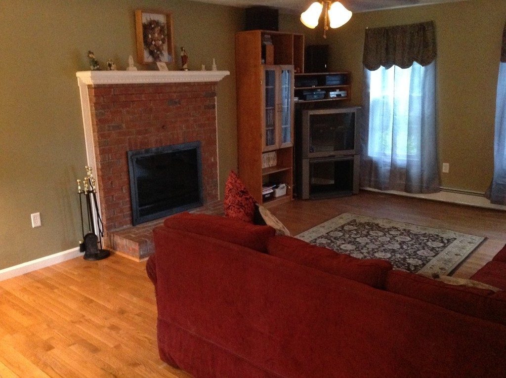 44 Tobin Road Leicester, MA 01611 - Photo 17 of 30 a living room with furniture a flat screen tv and a fireplace