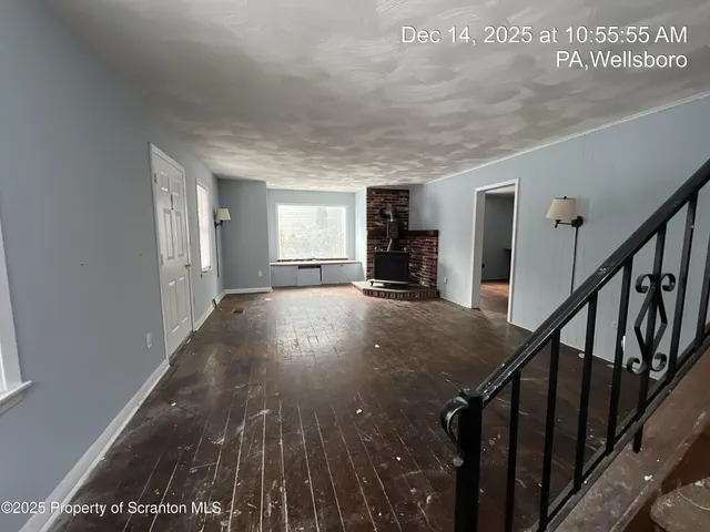 a view of a livingroom with wooden floor and stairs