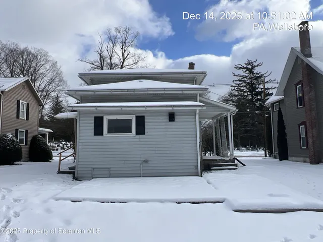 a view of a house with a snow in the yard