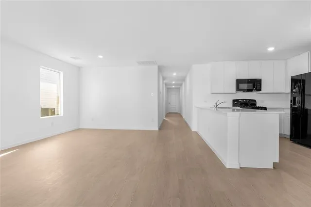 a view of kitchen with microwave and cabinets