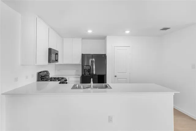 a kitchen with stainless steel appliances a sink and a refrigerator