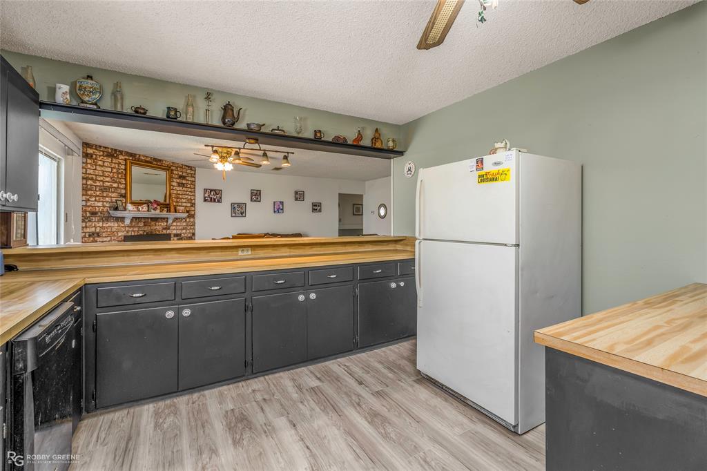 251 Tom Murphy Road Jamestown, LA 71045 - Photo 21 of 40 Kitchen with ceiling fan, freestanding refrigerator, wood counters, a textured ceiling, and dishwasher