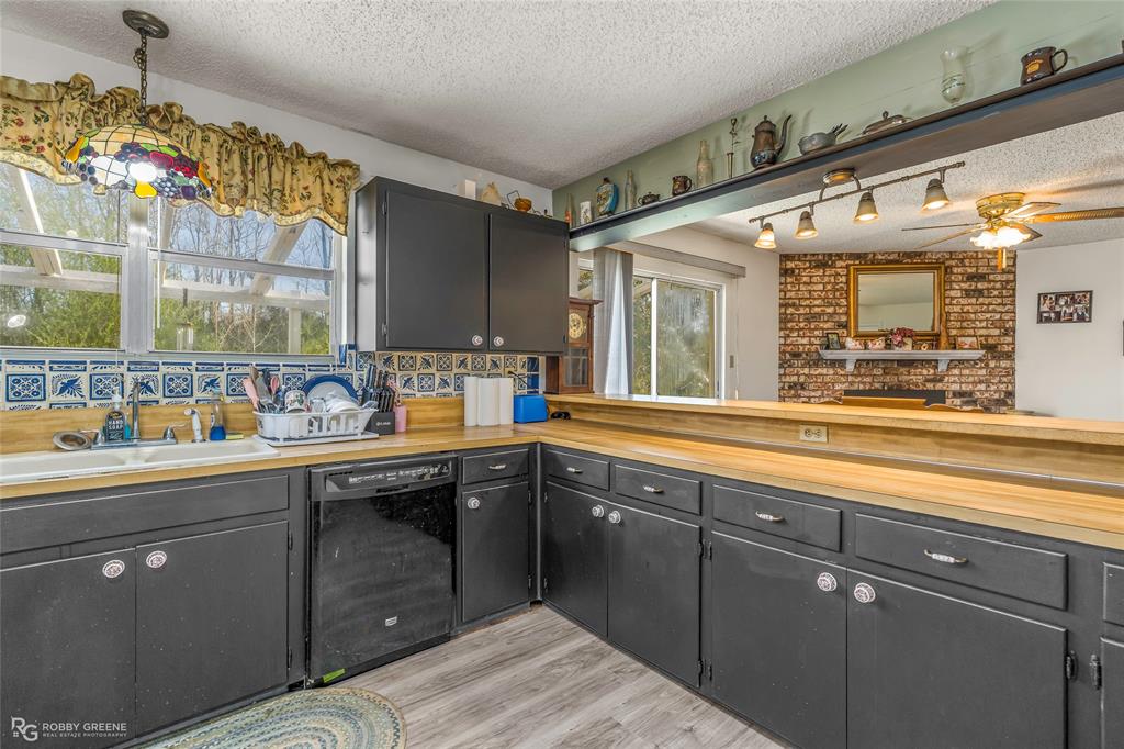 251 Tom Murphy Road Jamestown, LA 71045 - Photo 22 of 40 Kitchen with a textured ceiling, decorative light fixtures, black dishwasher, a ceiling fan, and light wood-style floors
